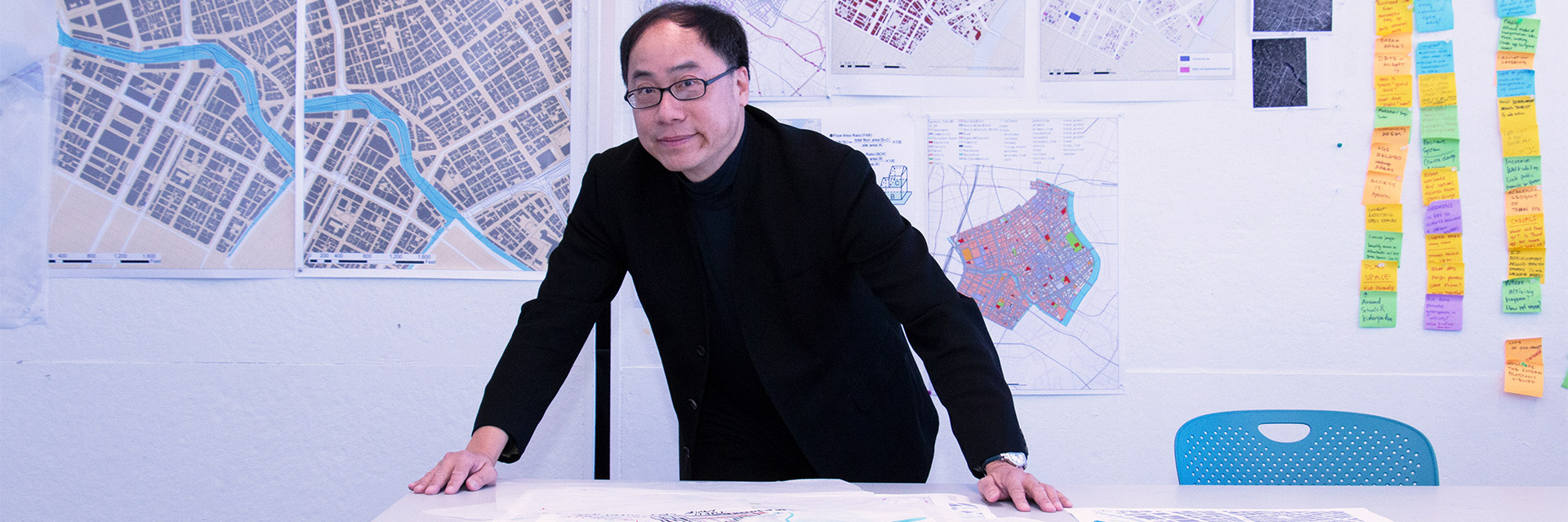 Perry Yang in front of urban design posters