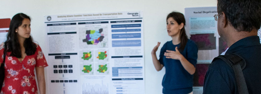 Clio Andress explains a GIS research poster.